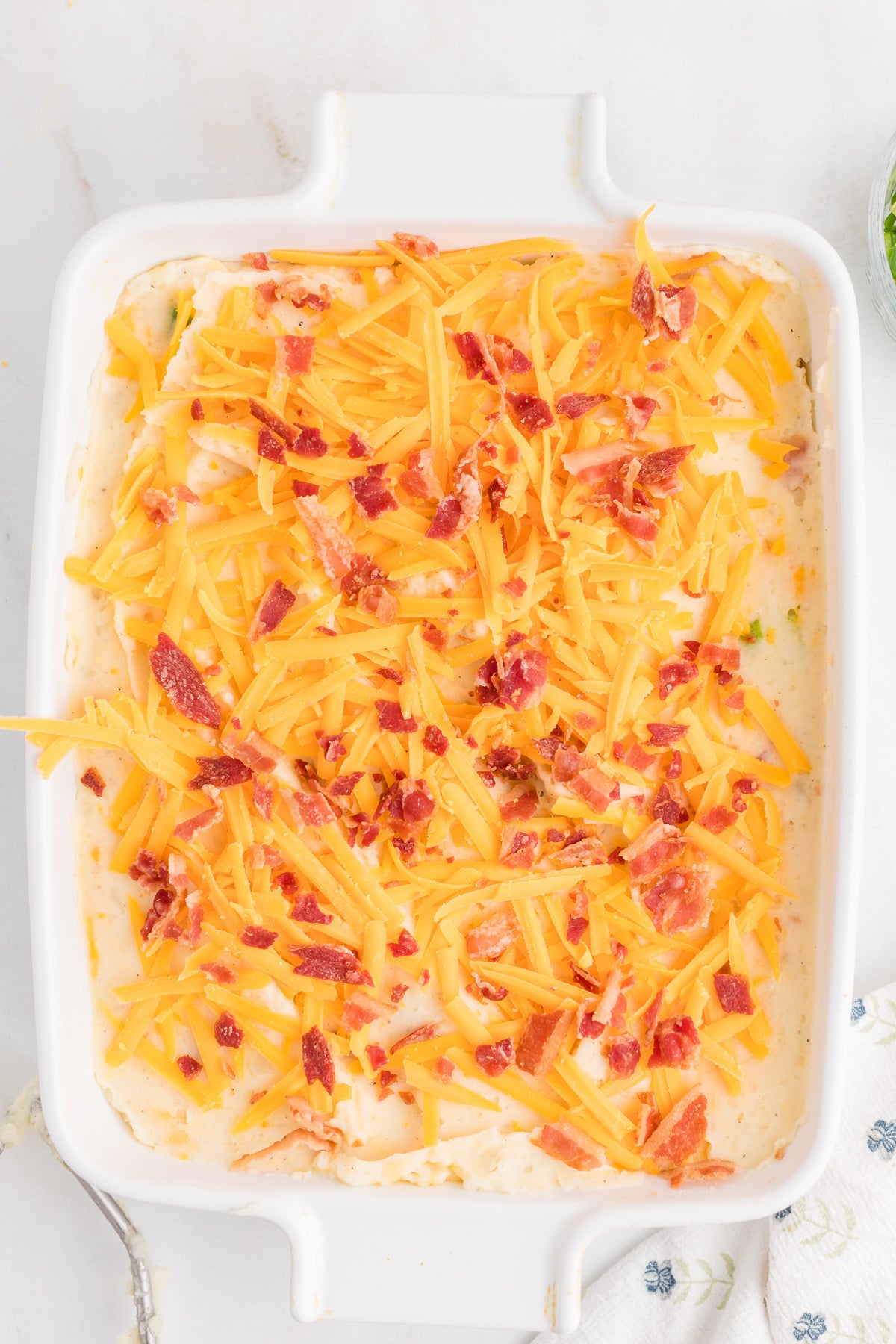 Remaining cheese and bacon are added to the top of the potato mixture.