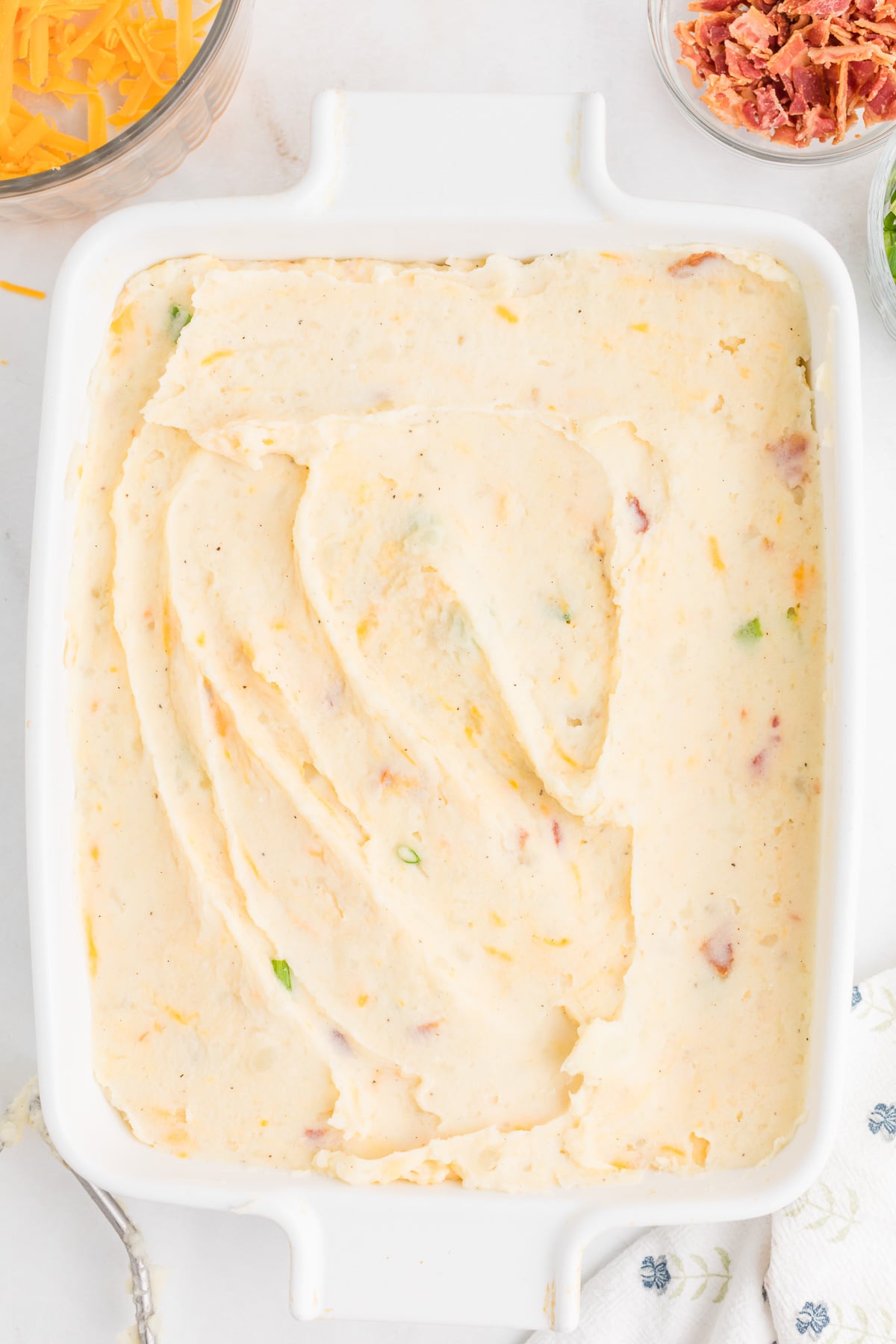 Mashed potato mixture is spread in a 9x13-inch baking dish.
