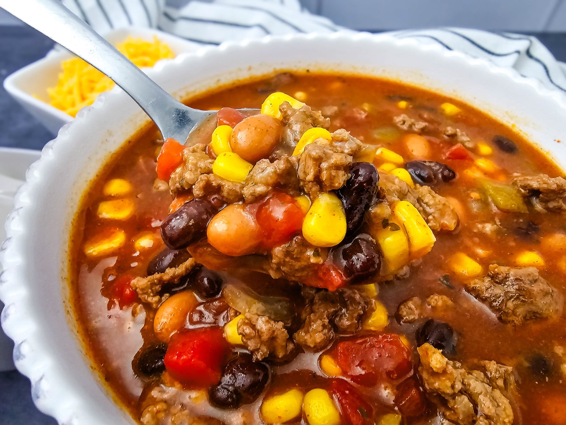 7 can taco soup served in a white bowl.