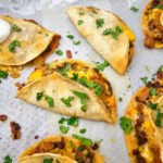 Crispy beef tacos on baking sheet.