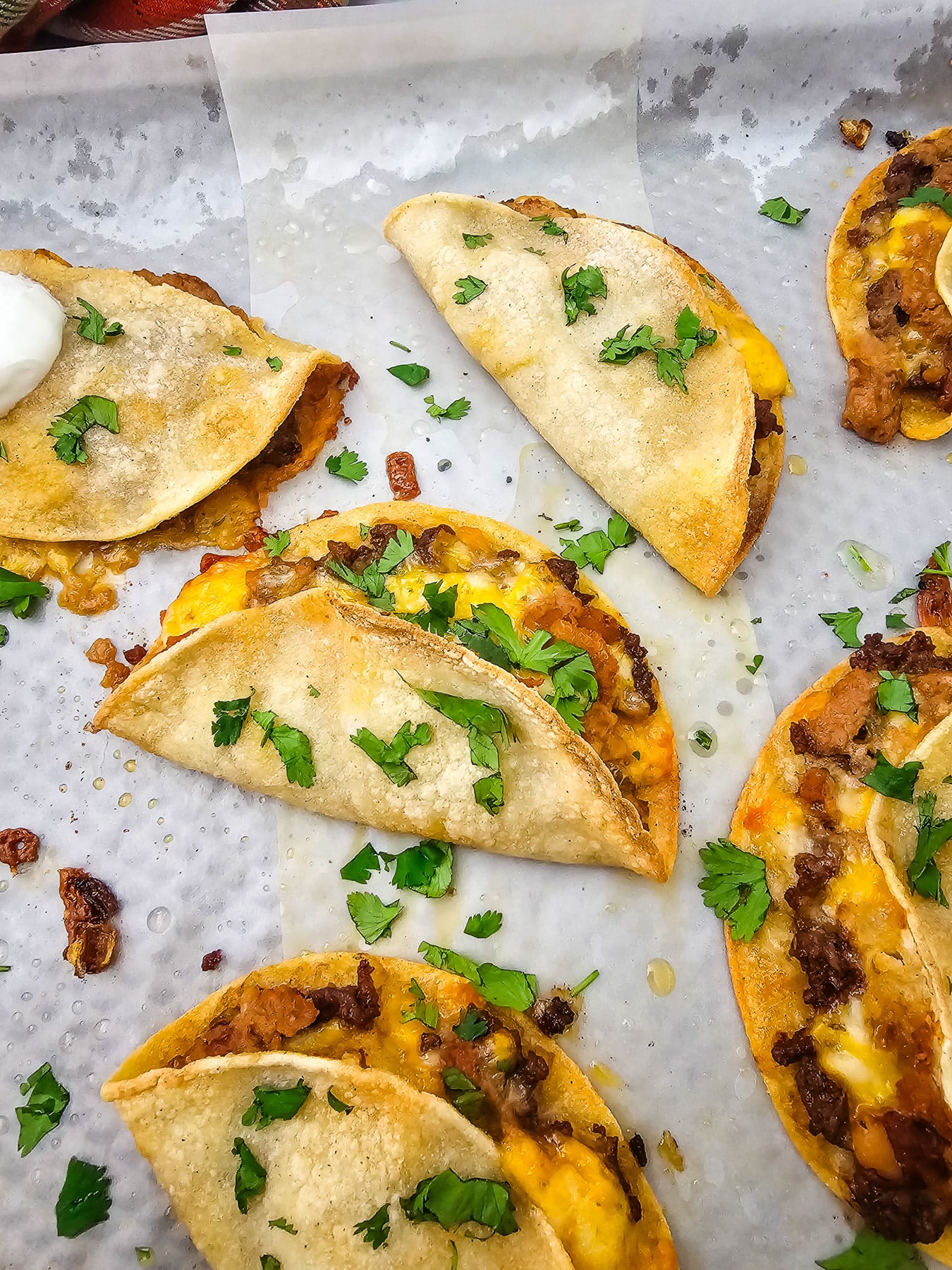 Crispy beef tacos on baking sheet.