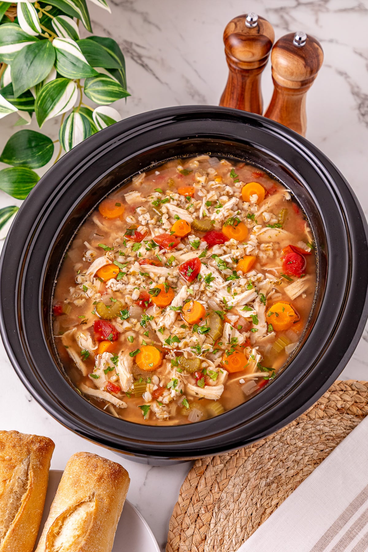 Slow cooker chicken and barley soup in crockpot ready to be served.