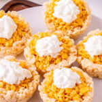 Mini pumpkin Rice Krispie treats on a white plate.