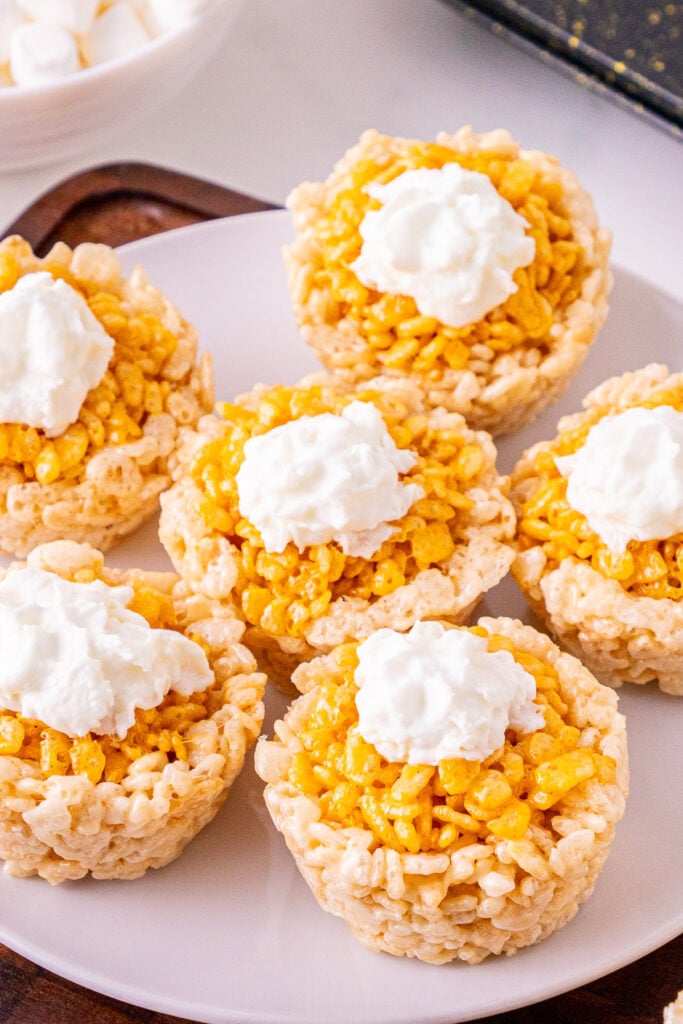 Mini pumpkin Rice Krispie treats on a white plate.