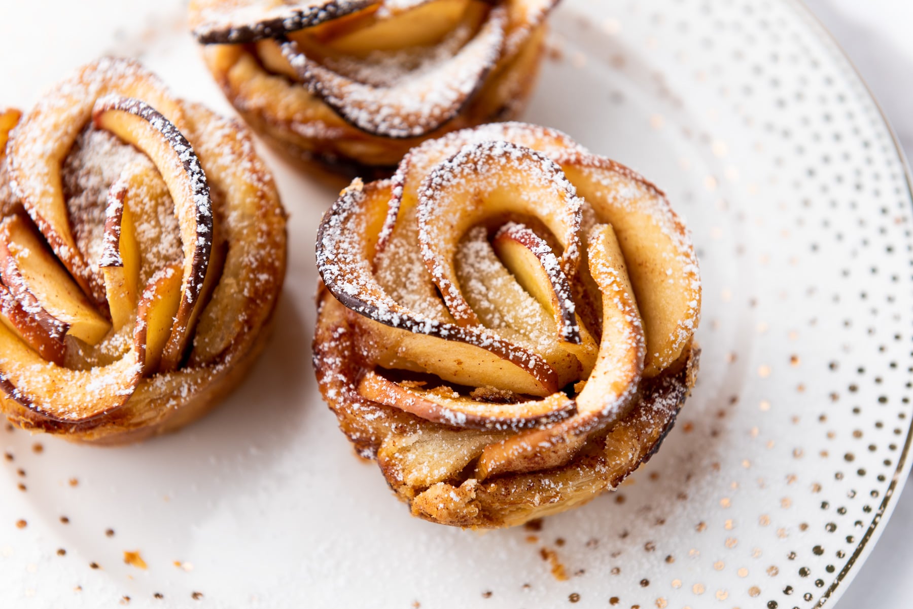 Puff pastry apple roses on a white plate.