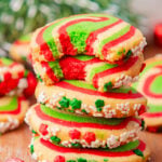 Stack of Christmas pinwheel cookies on a wooden board.