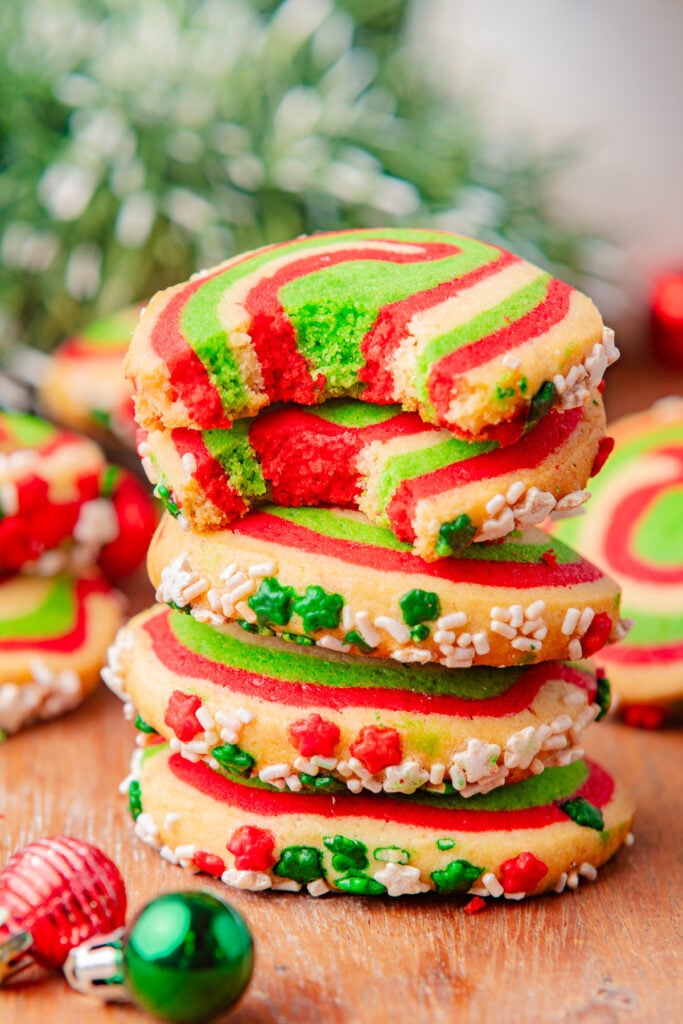 Stack of Christmas pinwheel cookies on a wooden board.