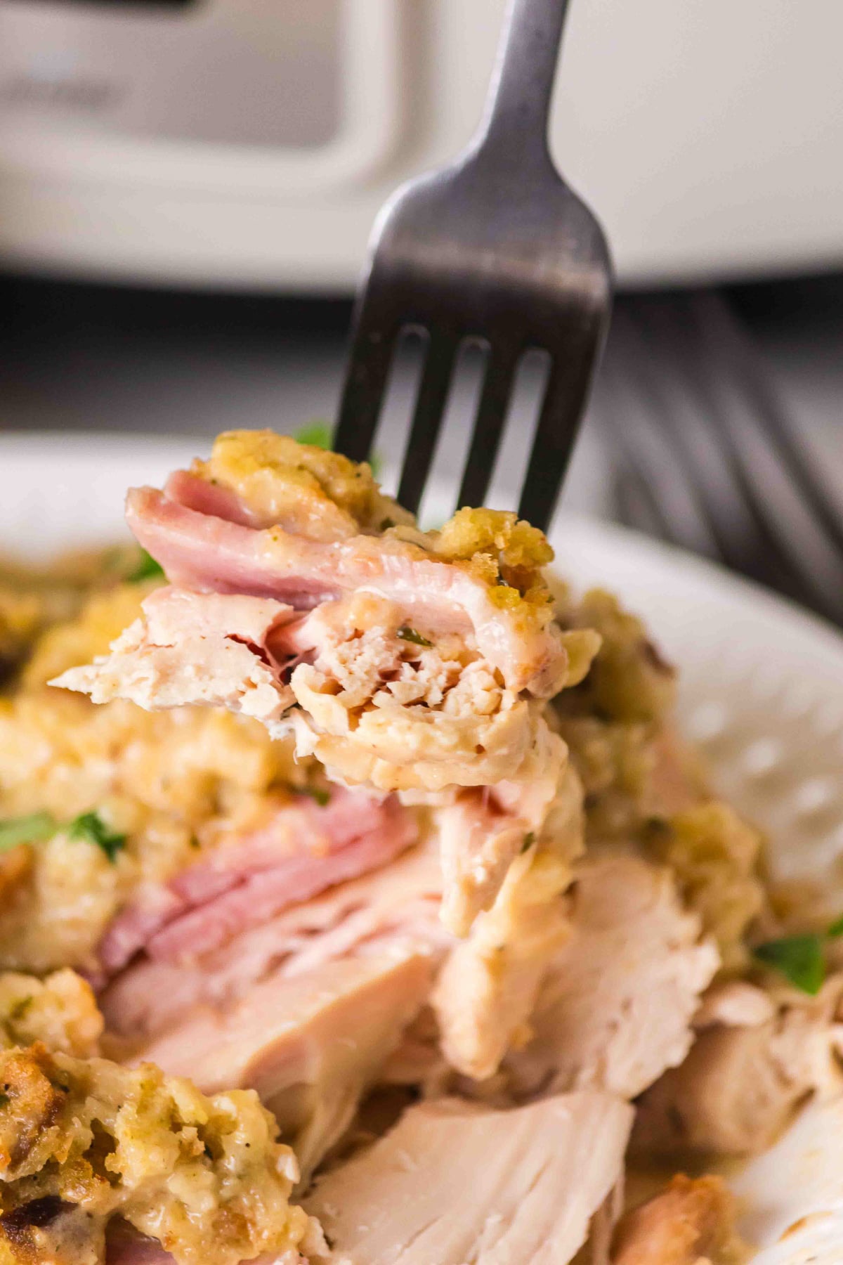 Bite shot of chicken cordon bleu casserole on a fork.