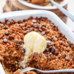 Pumpkin crispy with vanilla ice cream in 9x13-inch baking dish.