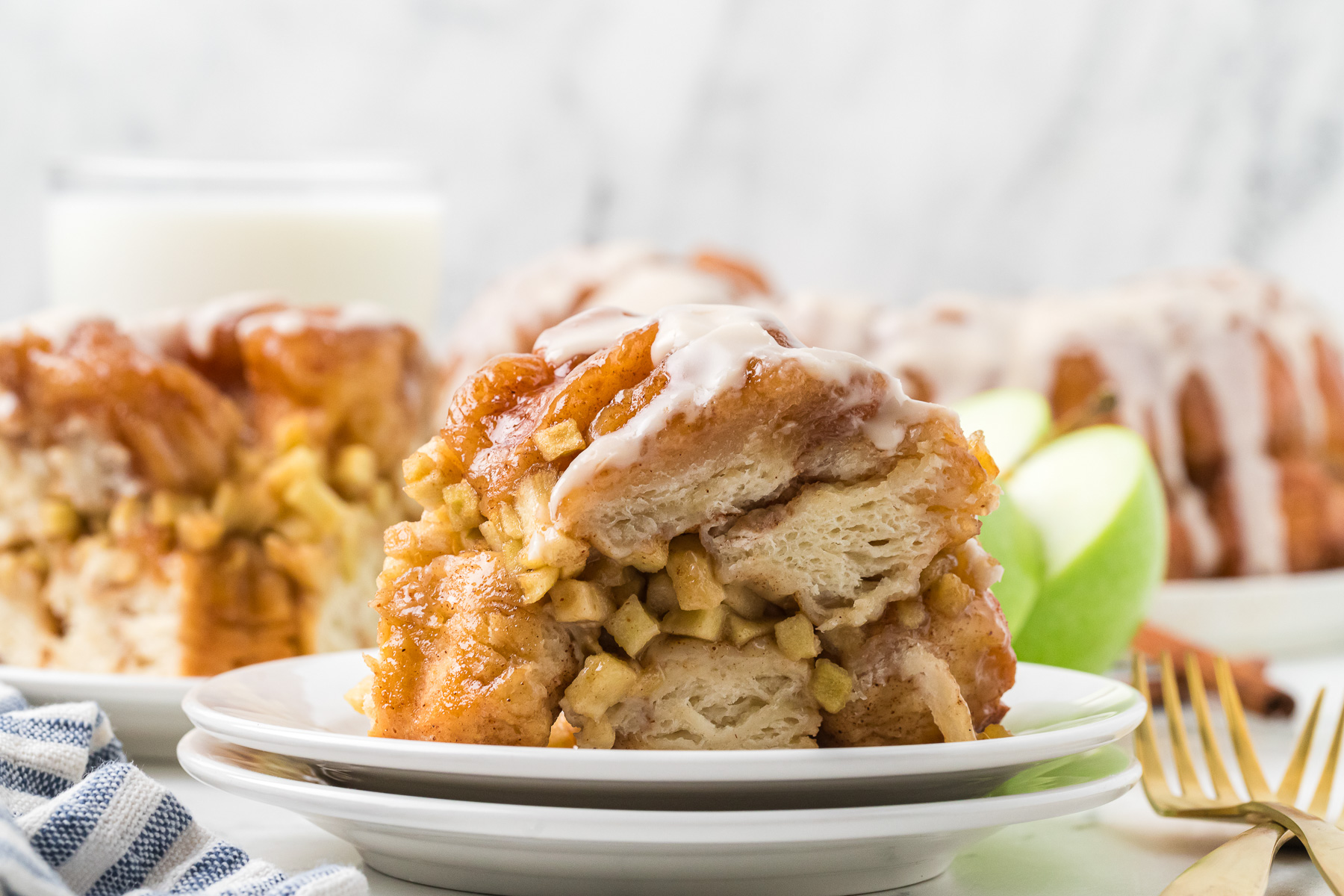 Serving of apple cinnamon monkey bread on white plate.