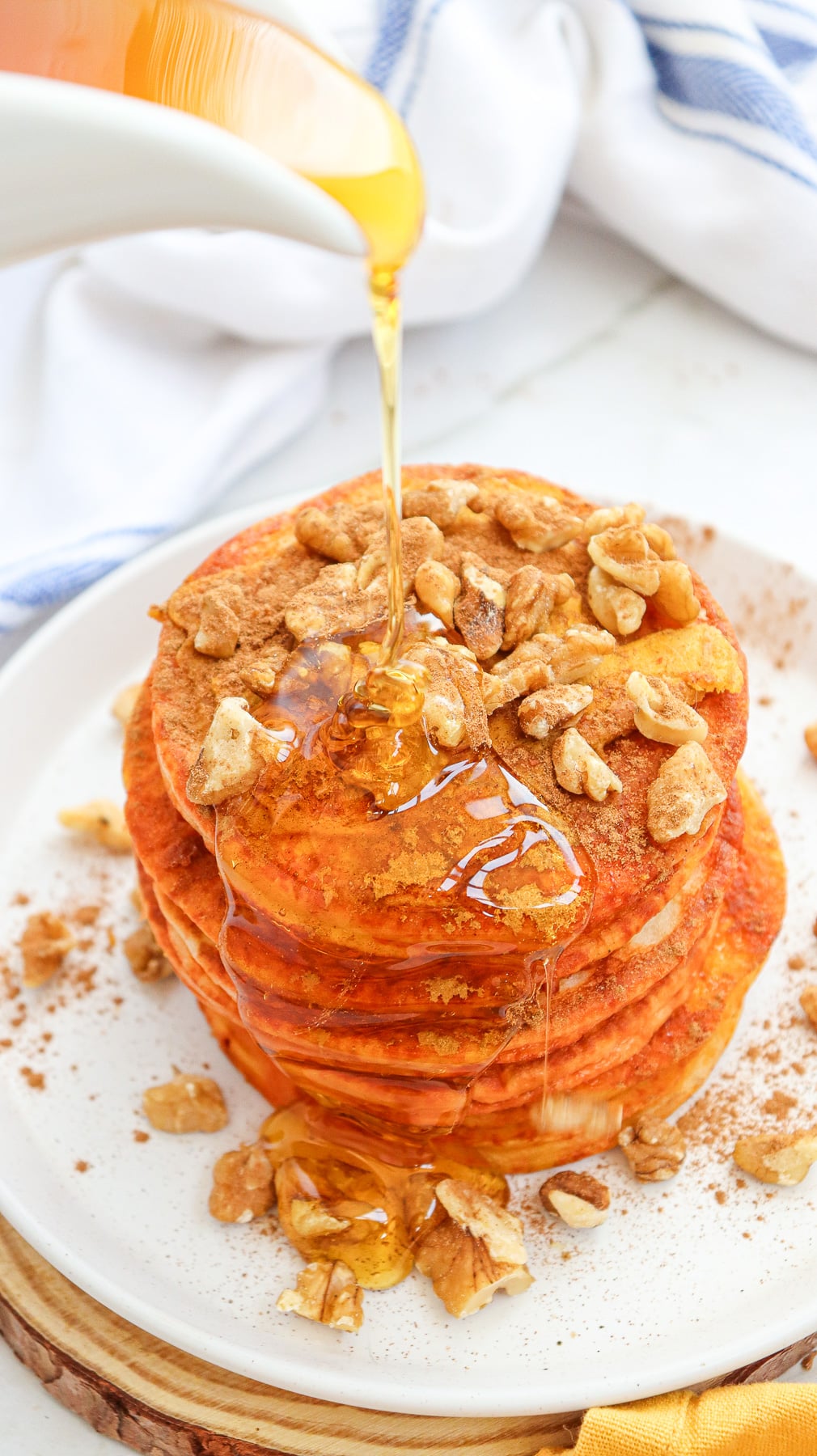 Syrup is poured on top of pumpkin pancakes.