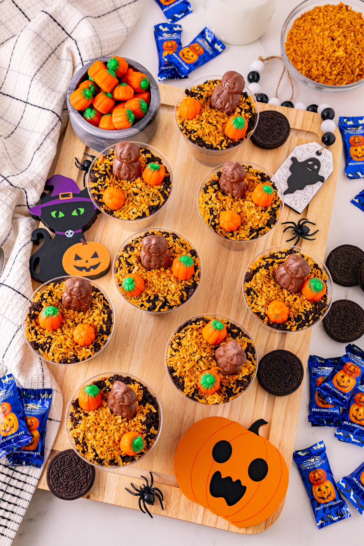 Pumpkin patch dirt cups ready on a board for a halloween party.