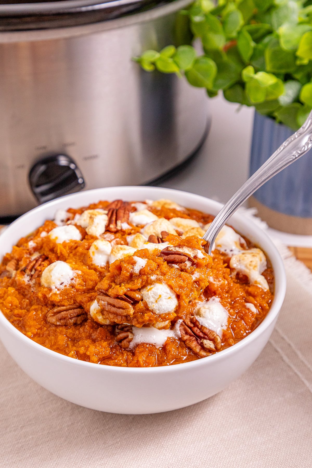 Finished dish of sweet potato casserole served. in a white bowl.