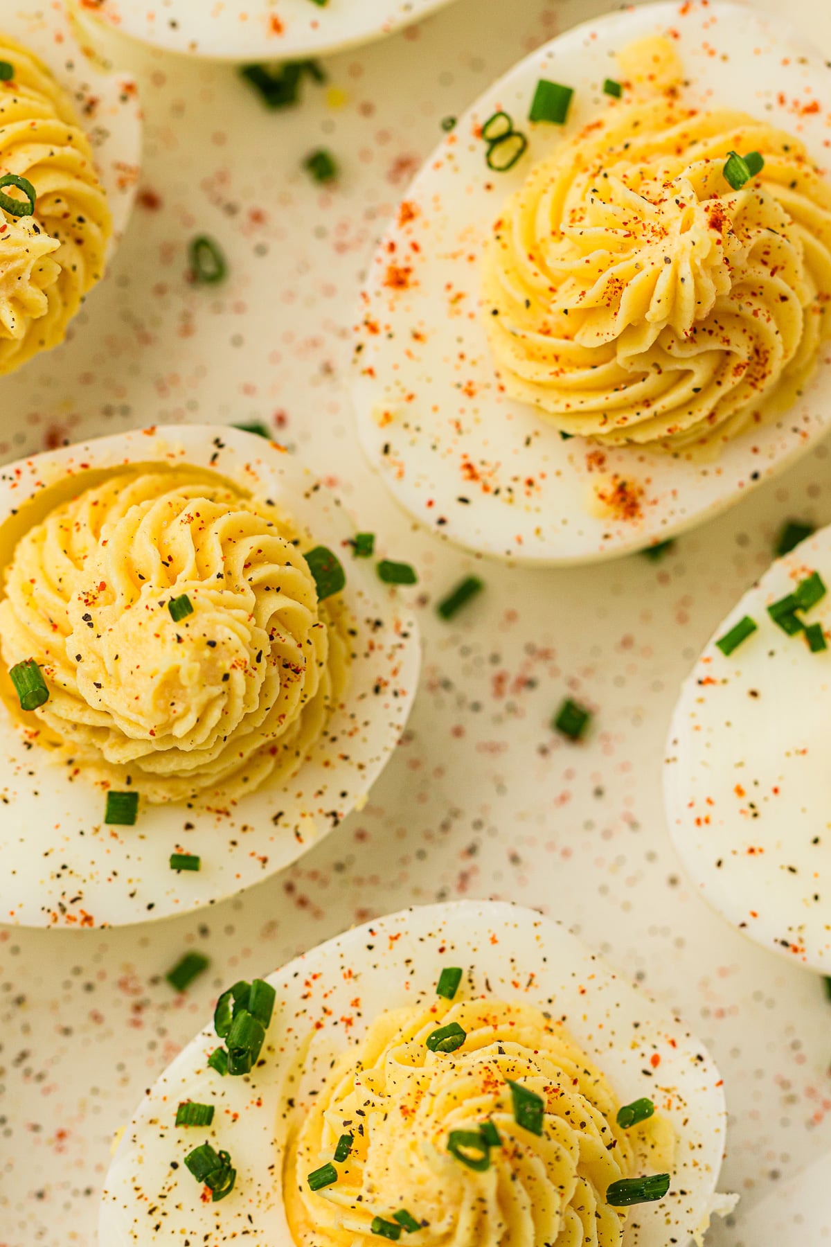 Overhead view of devilled eggs on a white plate.
