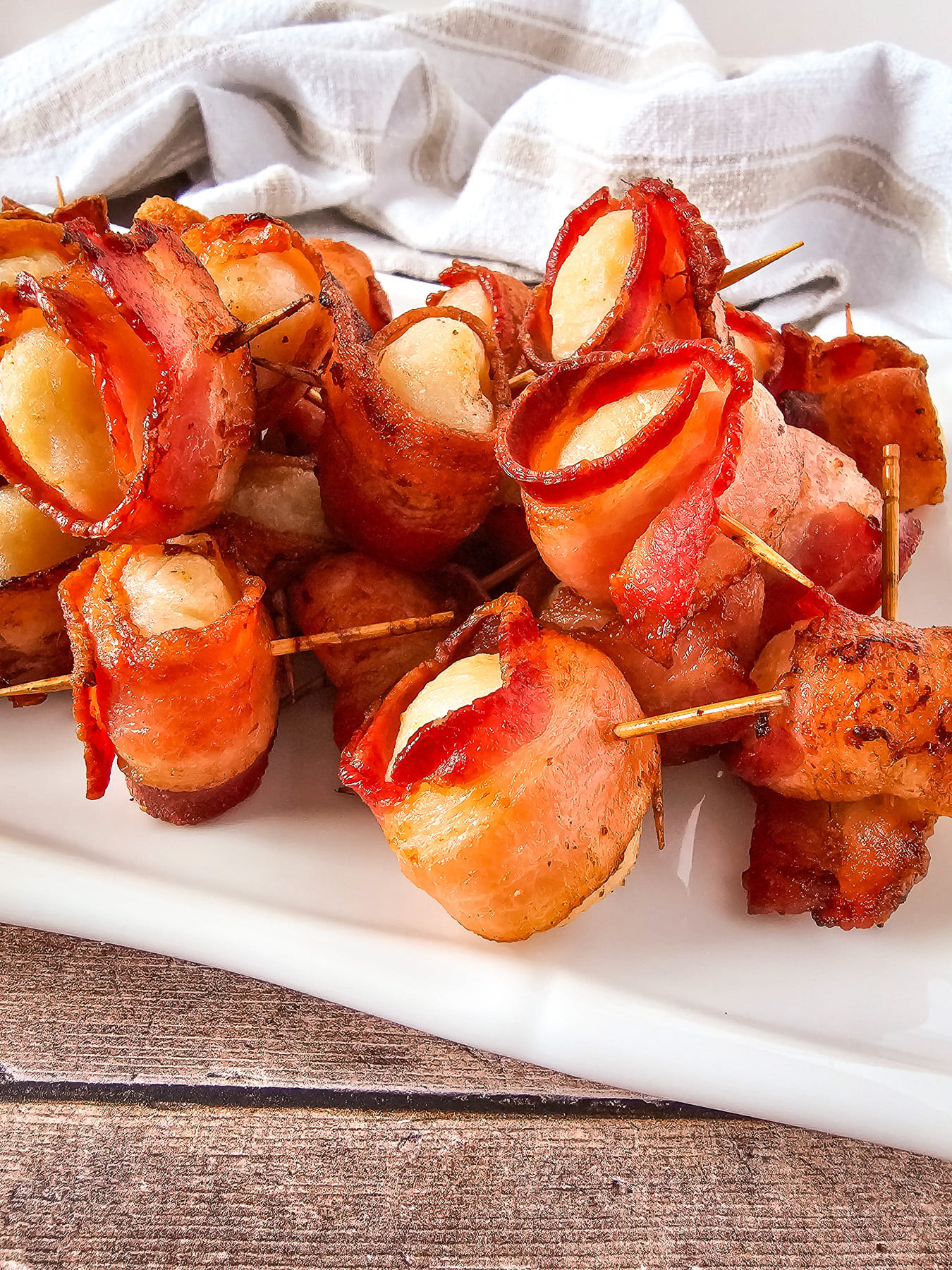 Bacon-wrapped water chesnuts arranged on a serving tray for a holiday party.