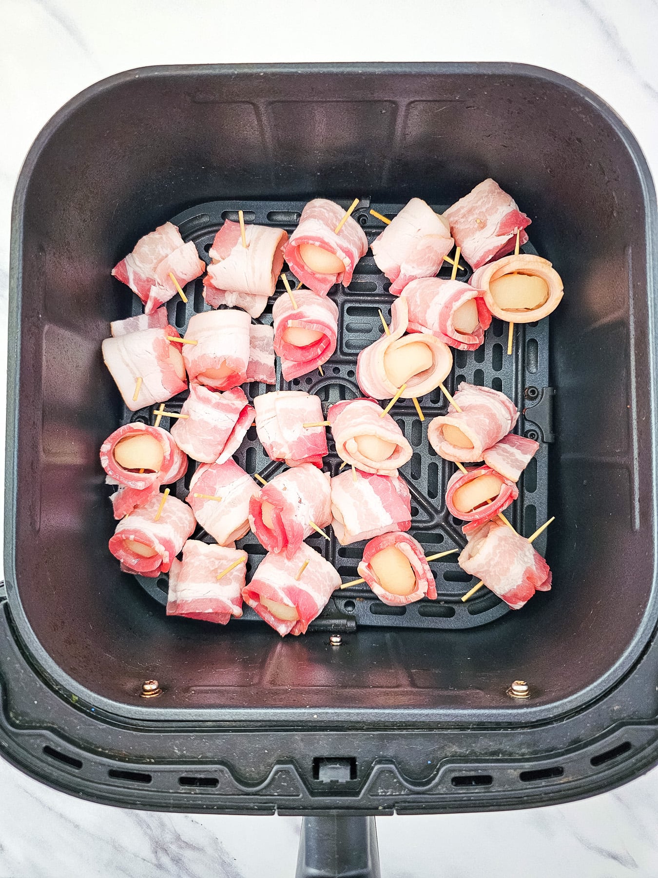 Bacon wrapped water chestnuts in bottom of air fryer basket.