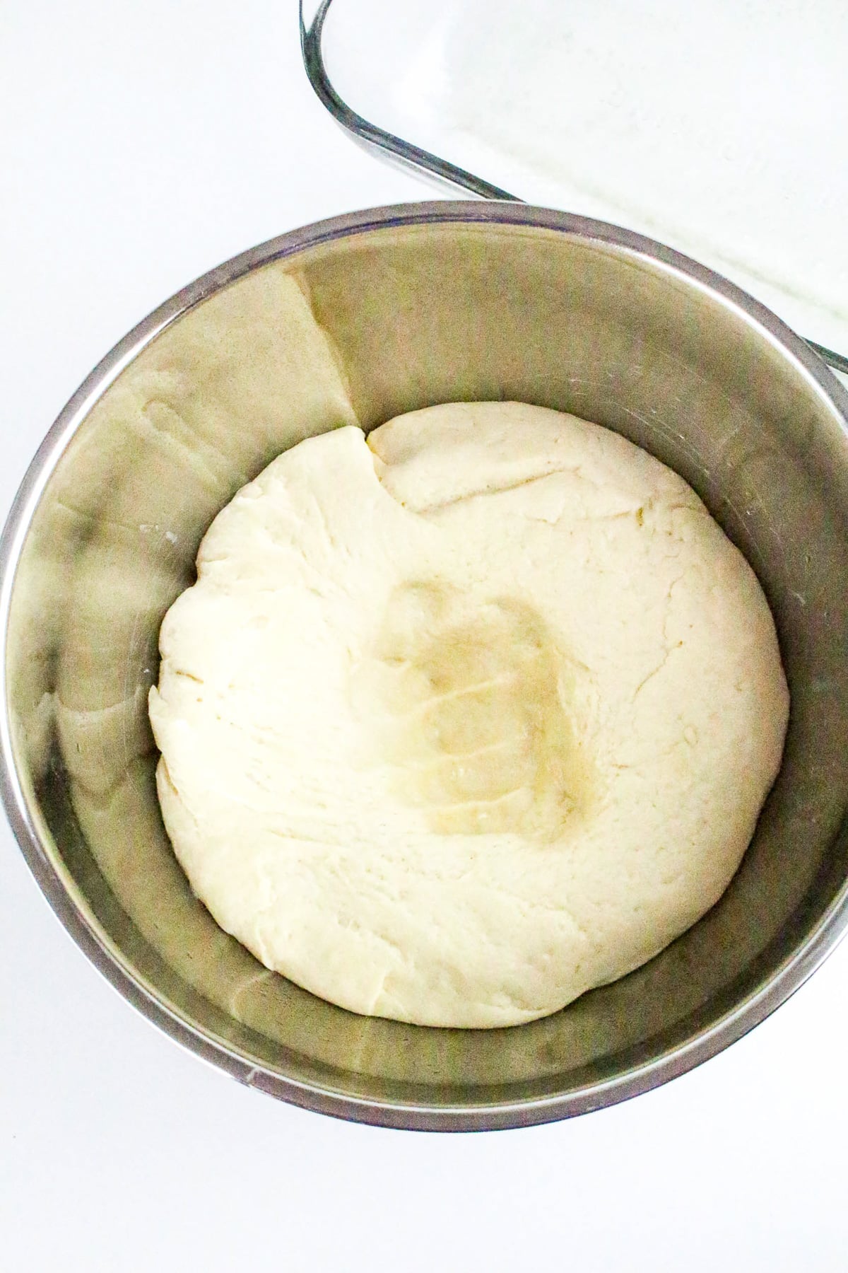 Risen dough is punched down in bowl.