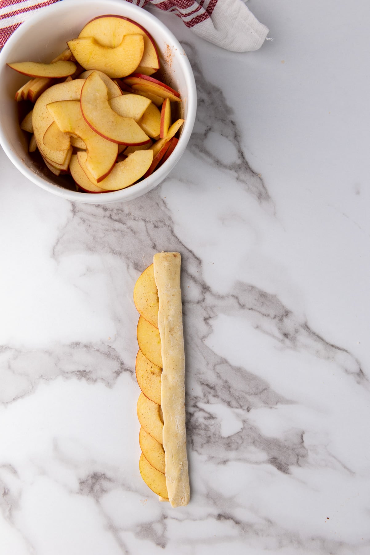 The other half of the strip is folded over part way on top of the apples.