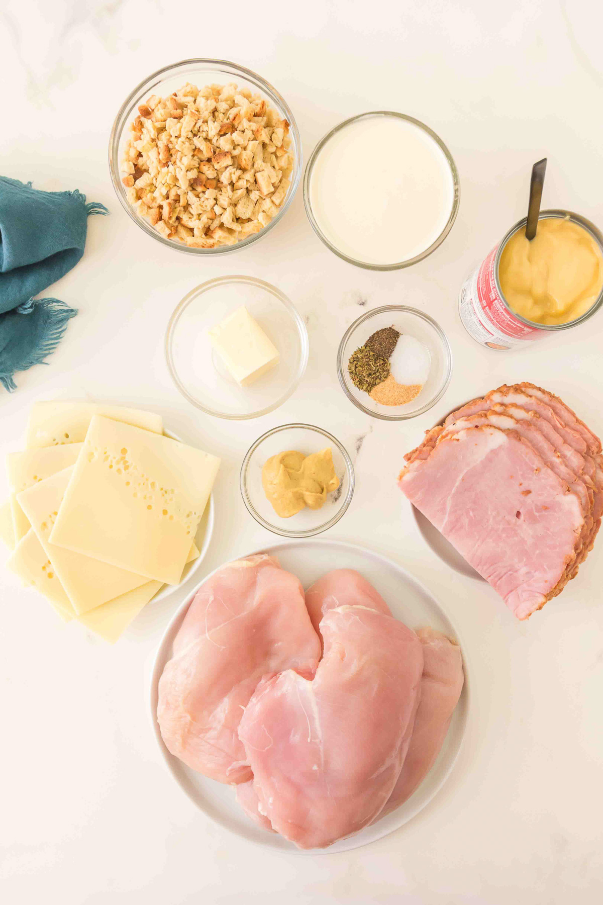 Ingredients for chicken cordon bleu crcokpot casserole laid out in small bowls on kitchen counter in prepration for the recipe.