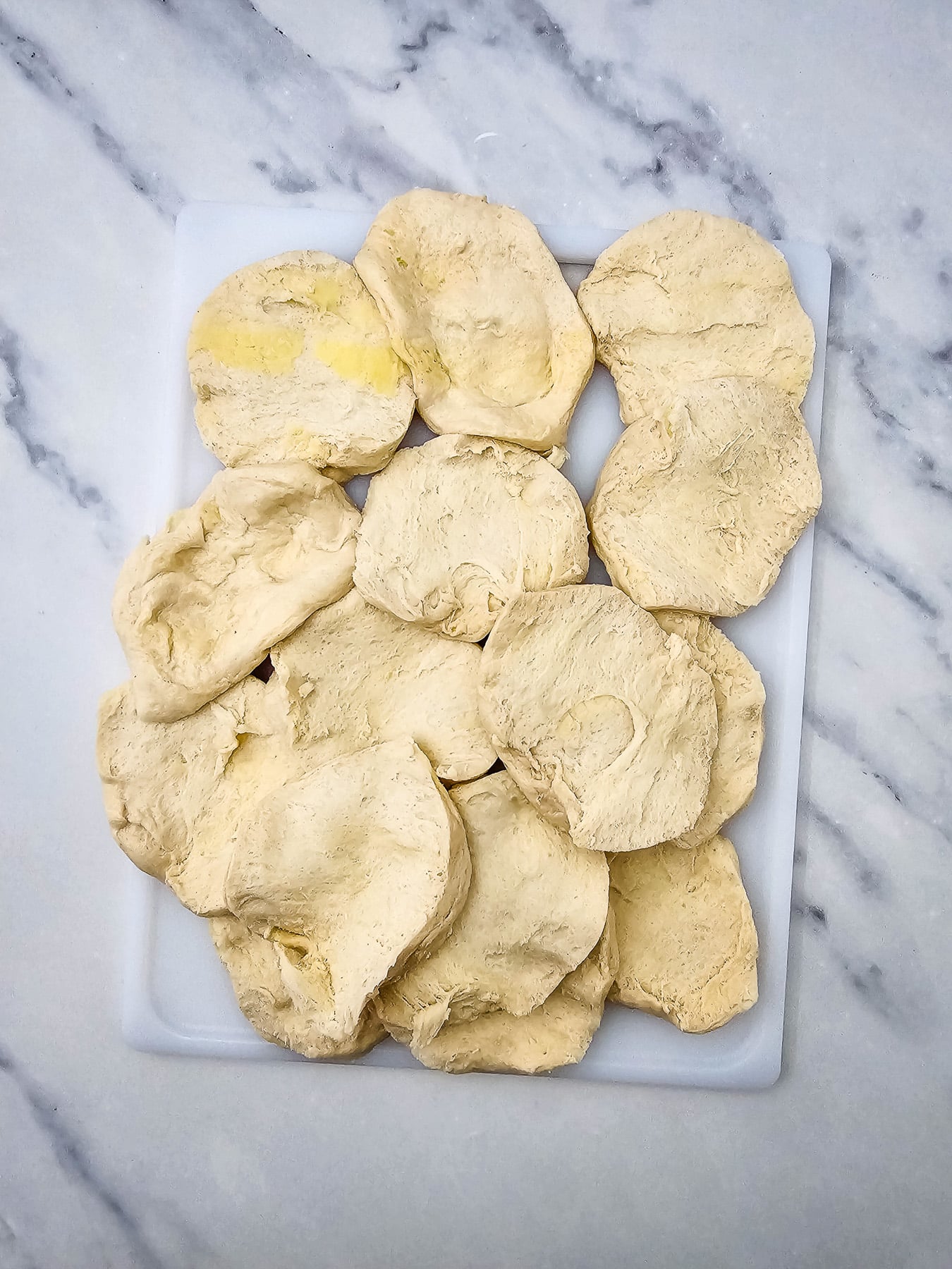 Biscuits are seprated and placed on cutting board.