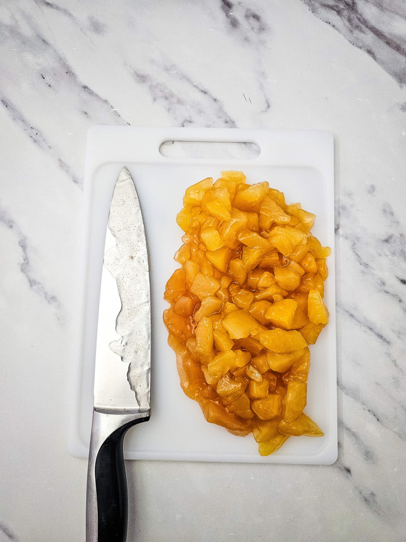 Apple pie filling is chopped into smaller pieces on cutting board.