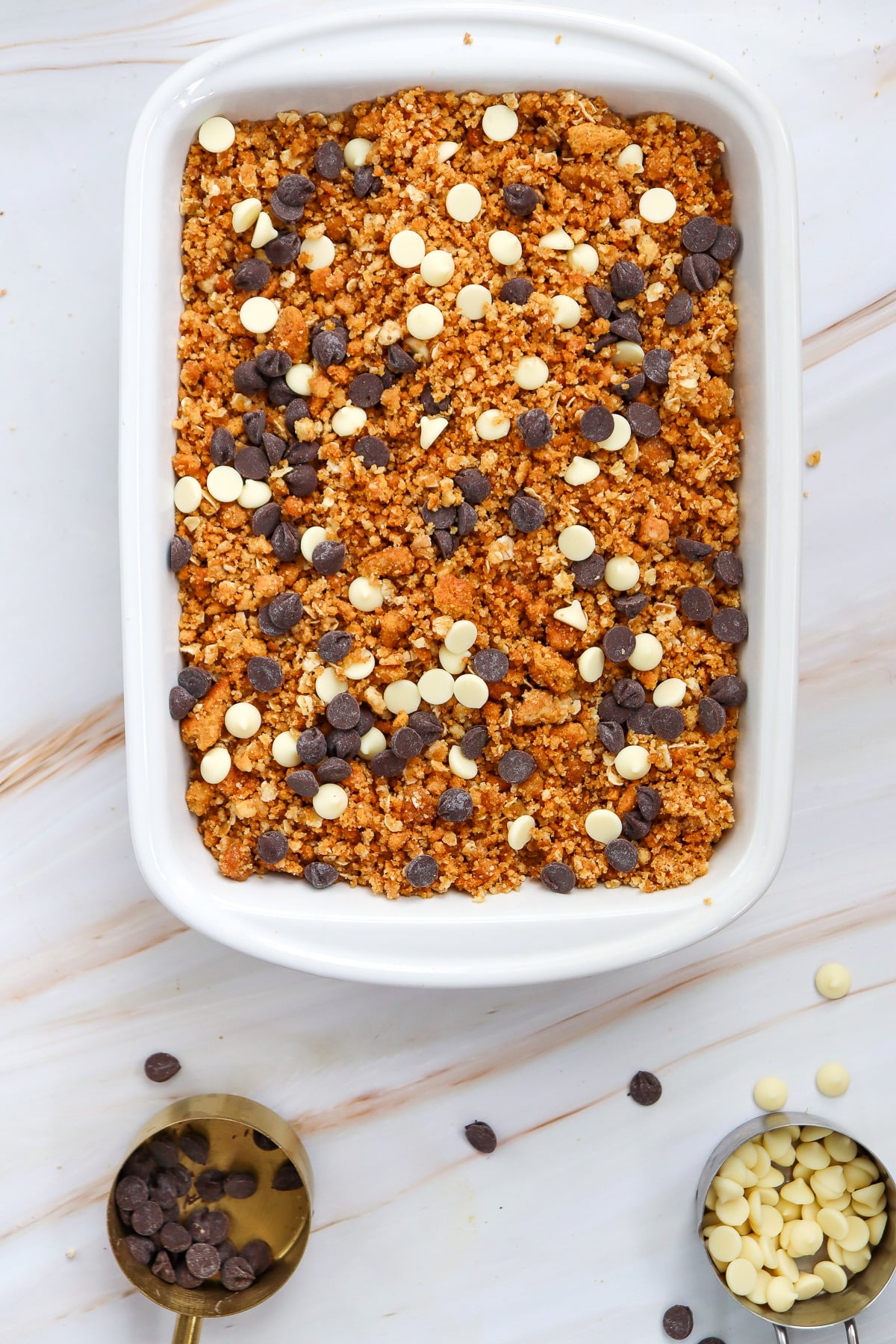 Topping and chocolate chip are sprinkled on top of the pumpkin mixture.