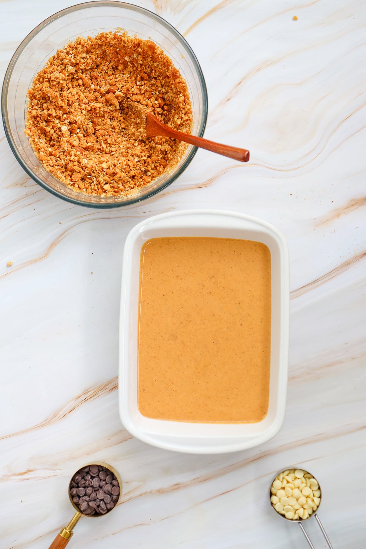 Pumpkin filling is added to the bottom of 9x13-inch baking dish.