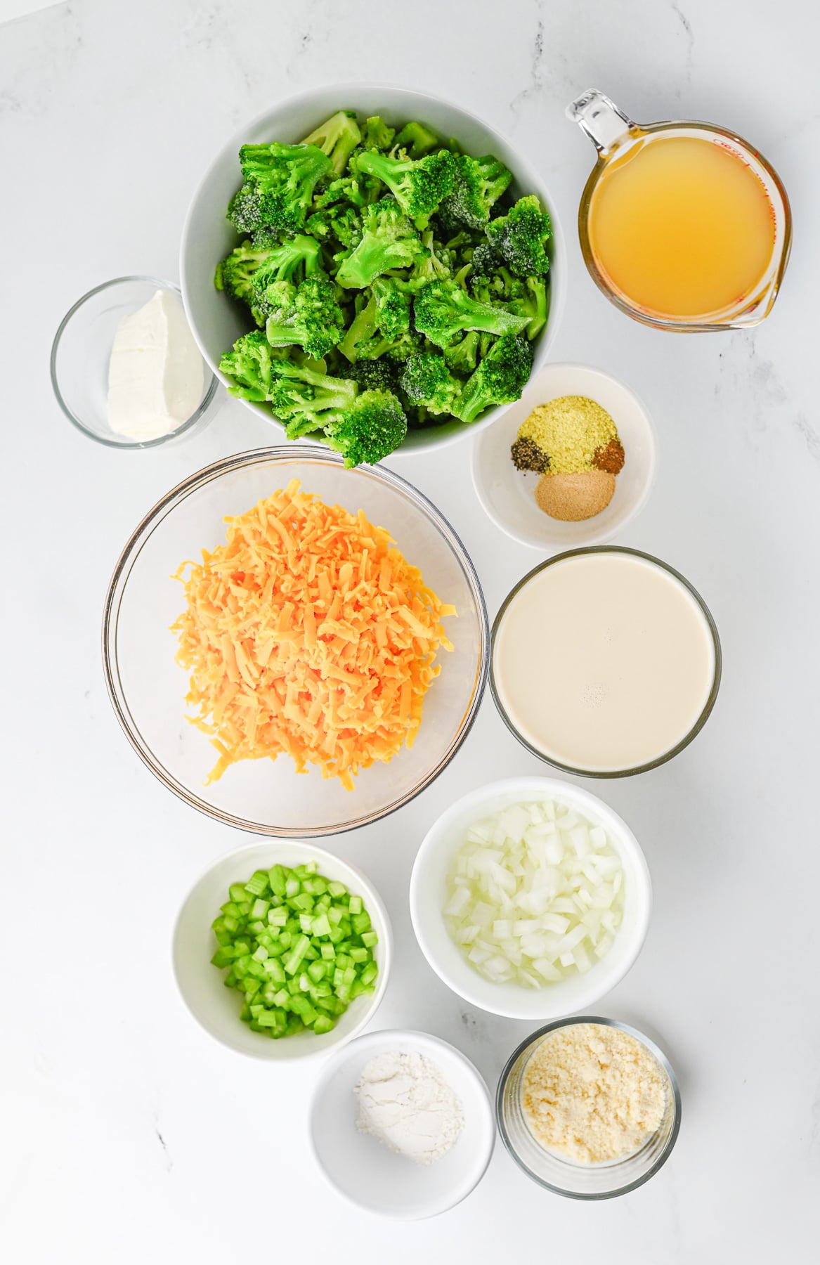 Ingredients for broccoli cheese soup laid out on counter in small bowls.