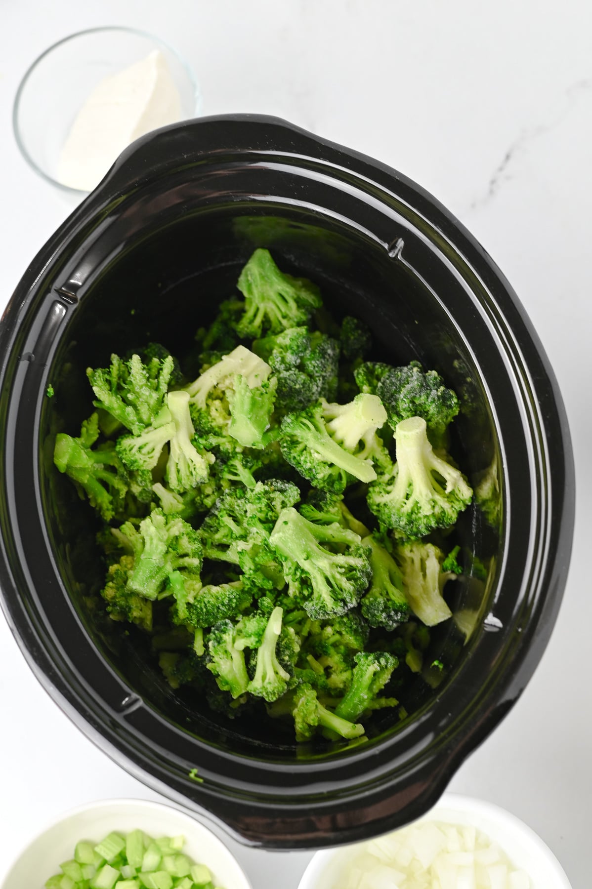 Broccoli is added to the crockpot.