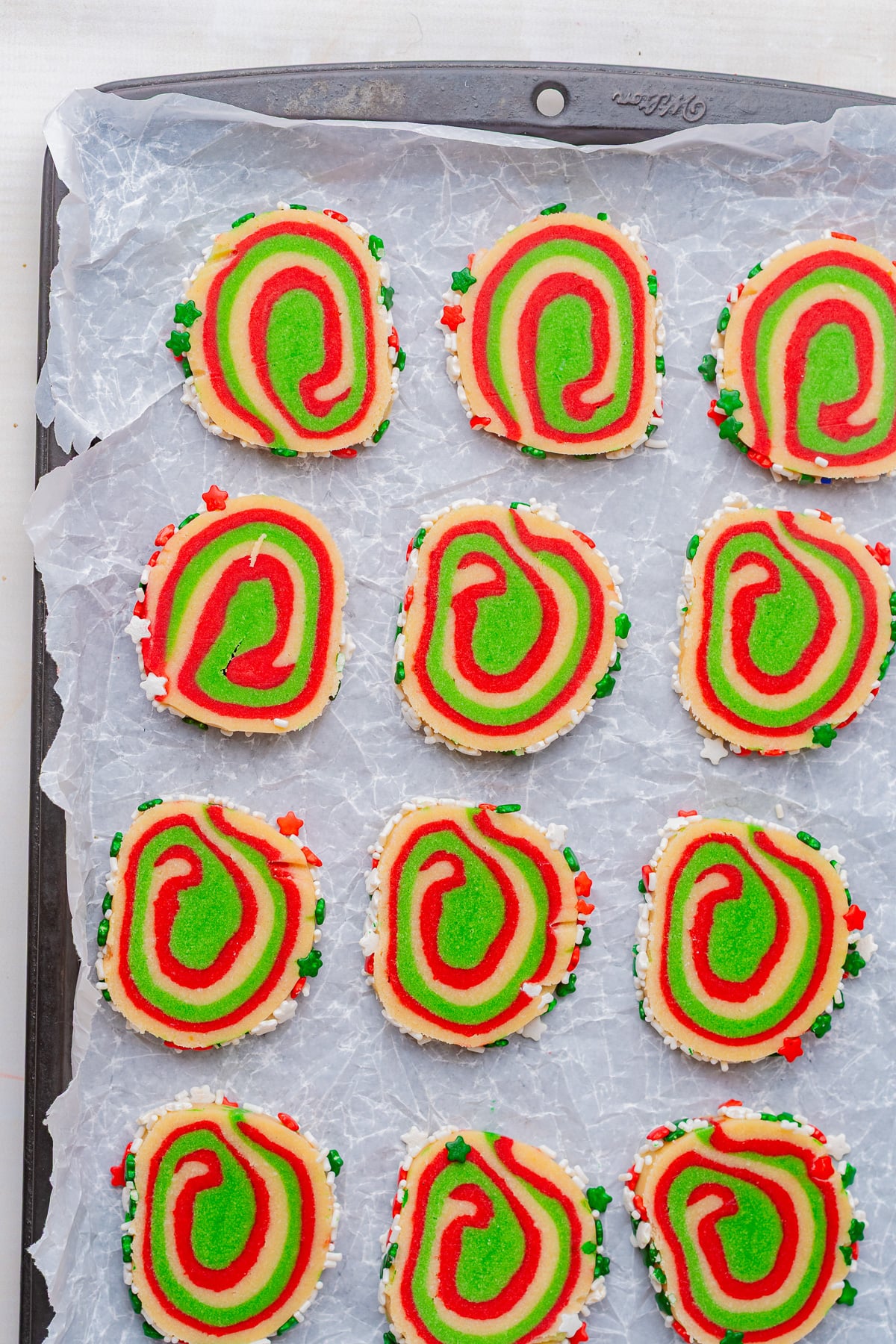Sliced cookies are placed on parchment lined baking sheet.