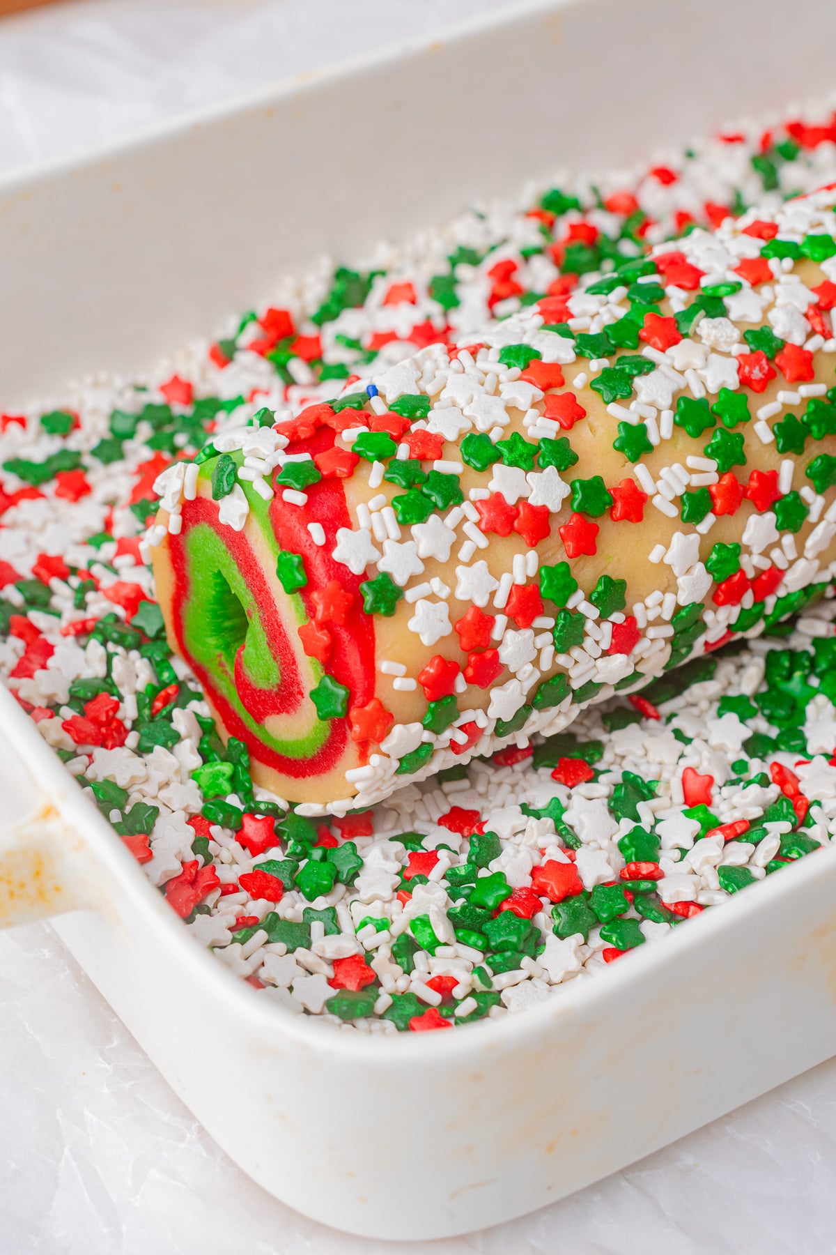 Sprnkles are covering the outside of the cookie dough log.