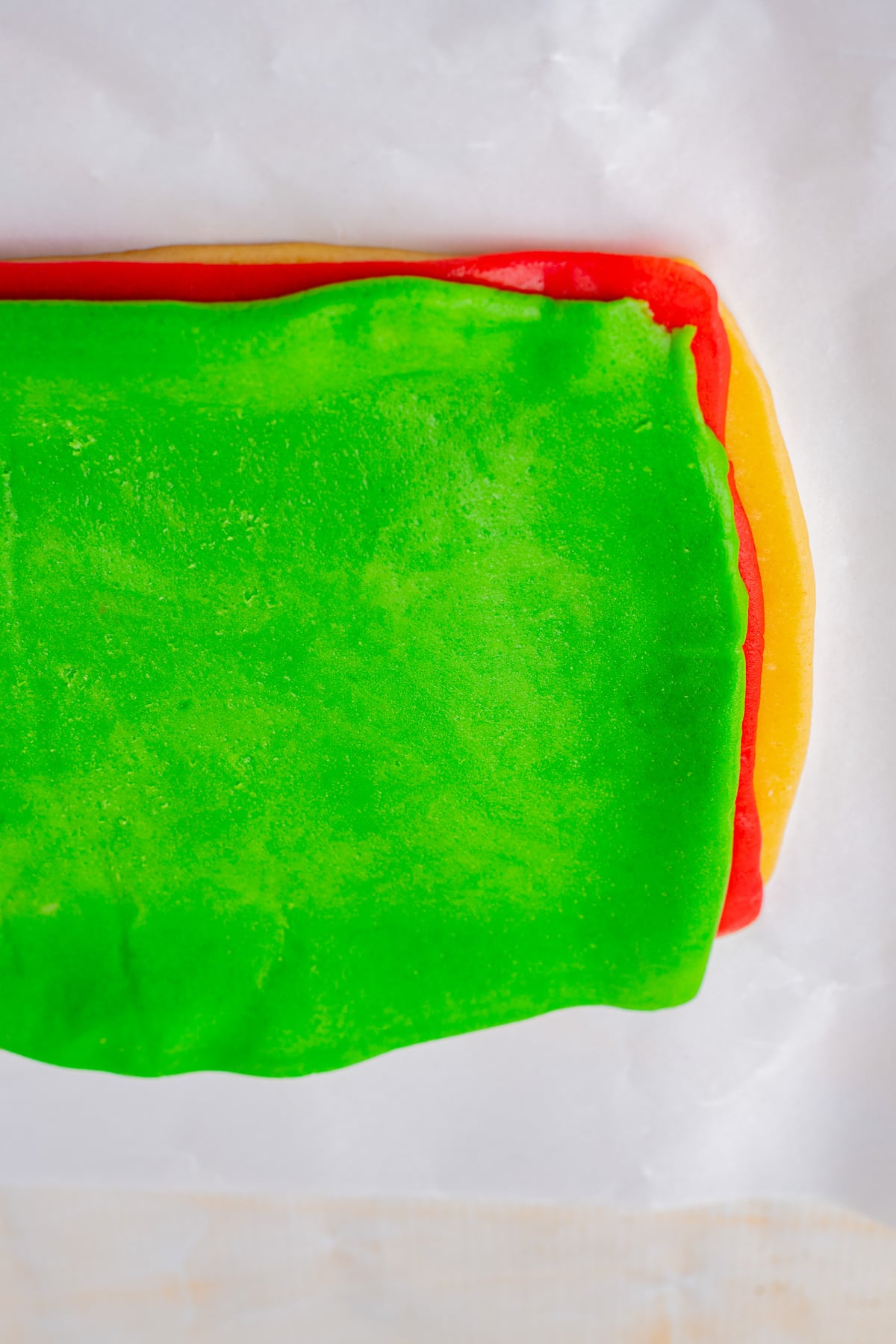 The white dough is placed on the bottom, followed by the red, then green.