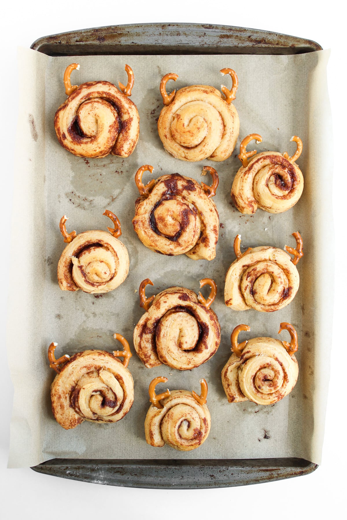 Cinnamon rolls drizzled with icing then the pretzels are pressed in.