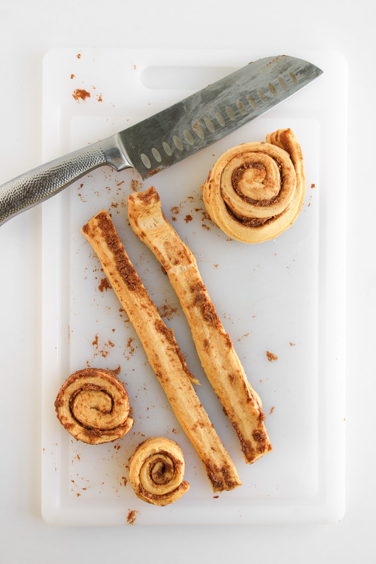 Unrolled cinnamon rolls on cutting board.