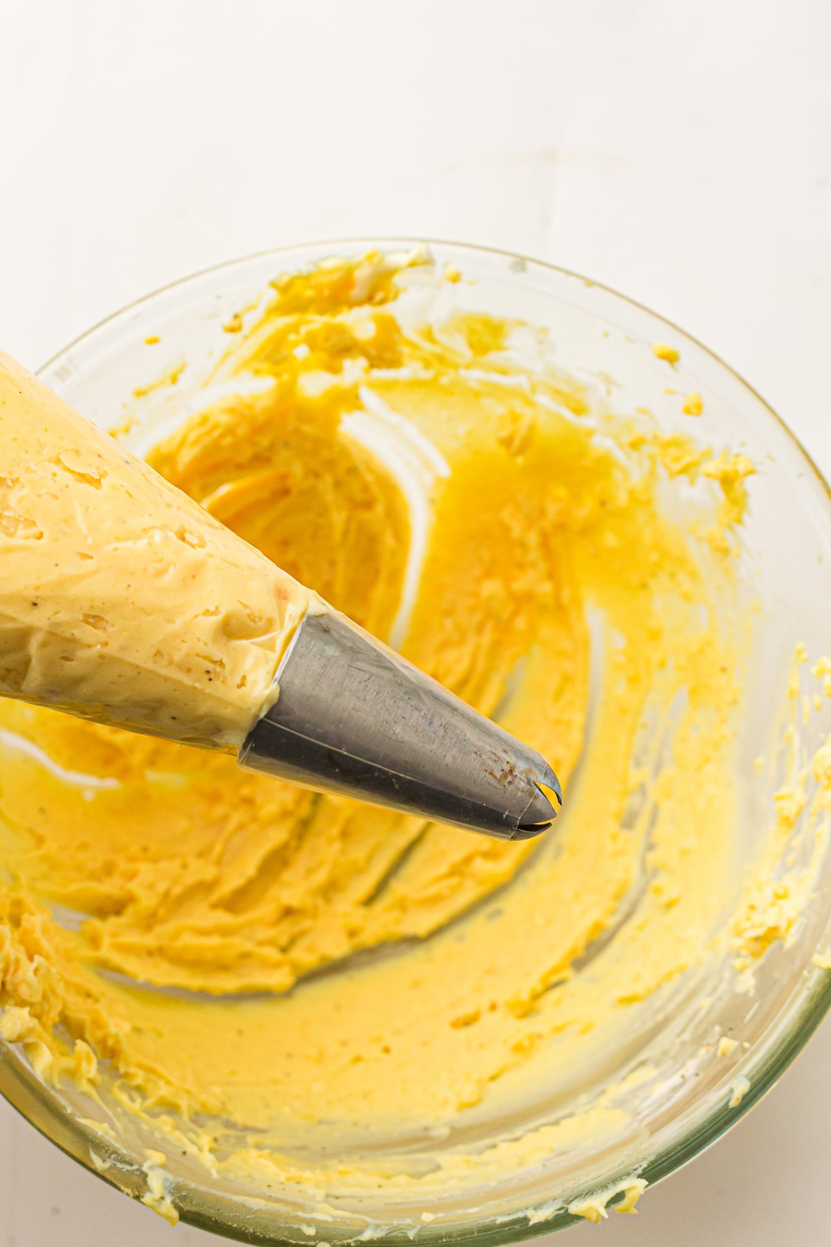 Egg yolk mixture is placed into a piping bag.
