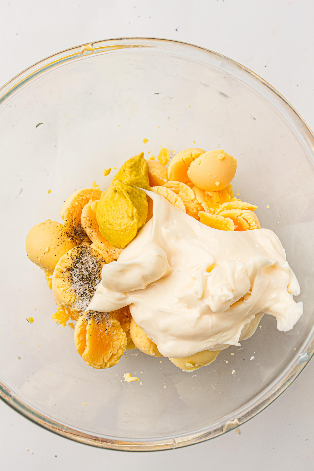 Yolks are mashed with mayonnaise in small bowl.