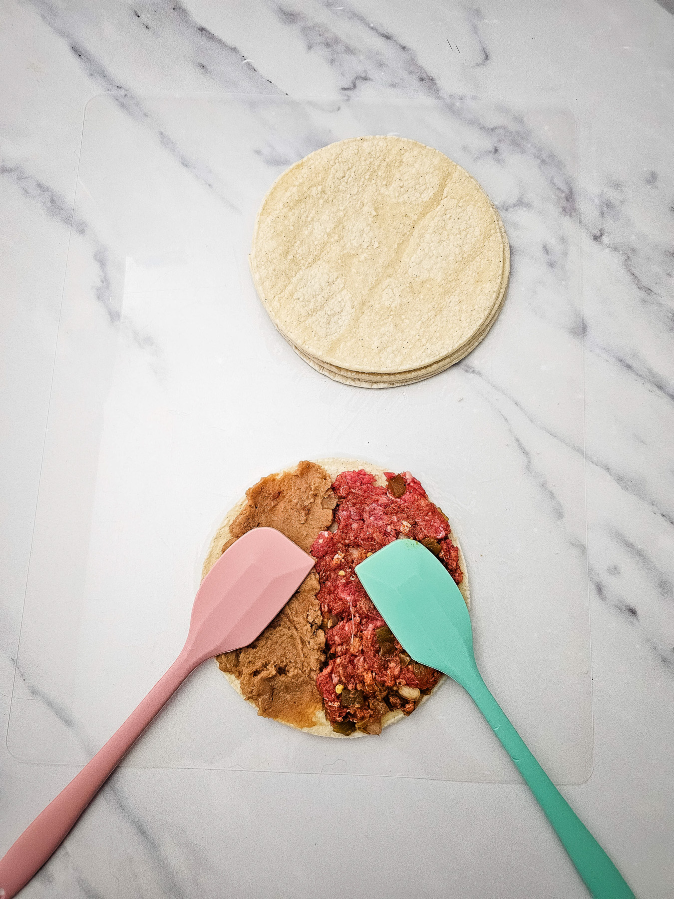 Ground beef mixture is spread on the tacos.