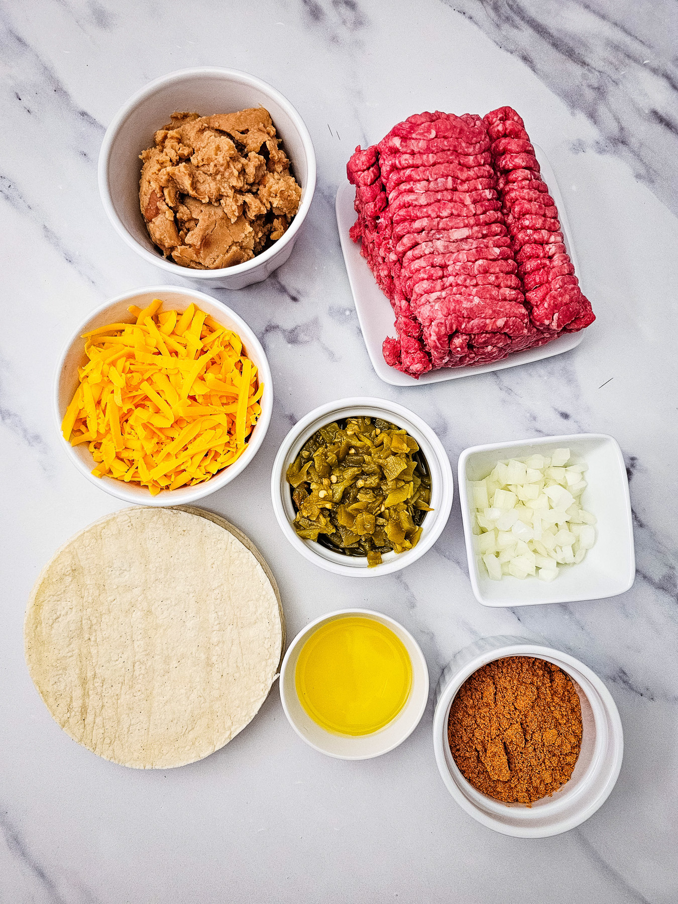 Ingredients for baked beef tacos laid out on counter in small bowl.
