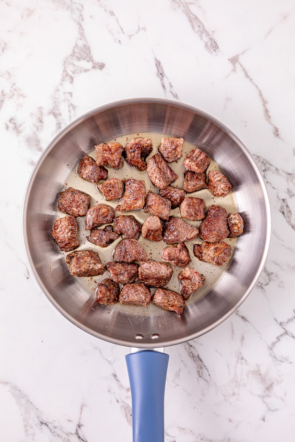 Seasoned beef in skillet.