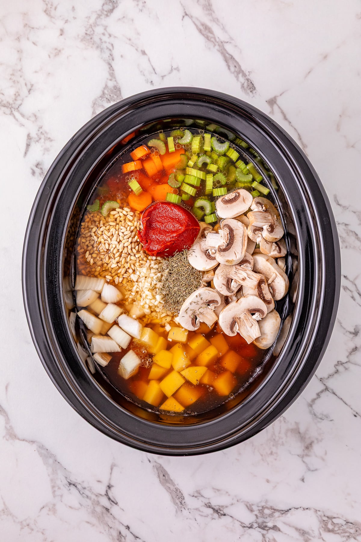 Tomato paste, Worcestershire sauce and dried thyme are added to the crockpot.