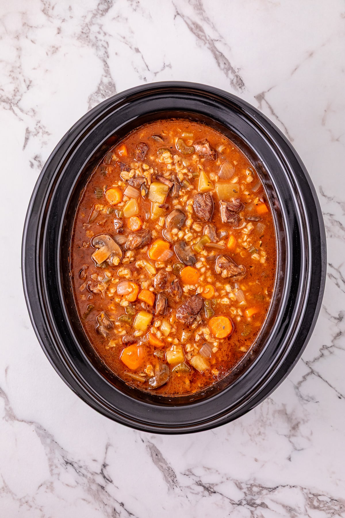 Cooked beef barley soup in slow cooker.