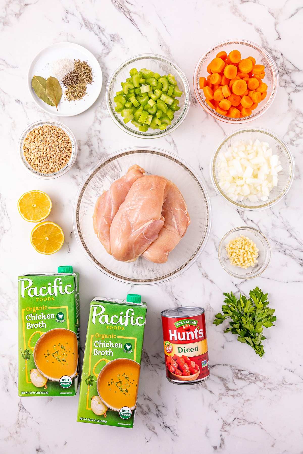 Ingredients for crockpot chicken and barley soup in small bowls on kitchen counter.