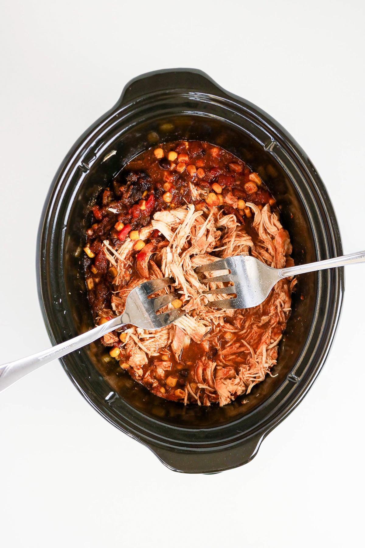 Shredded chicken is added back to the crockpot.