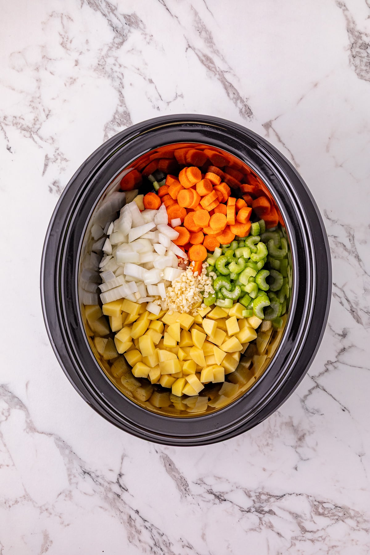 First set of ingredients placed in bottom of slow cooker.