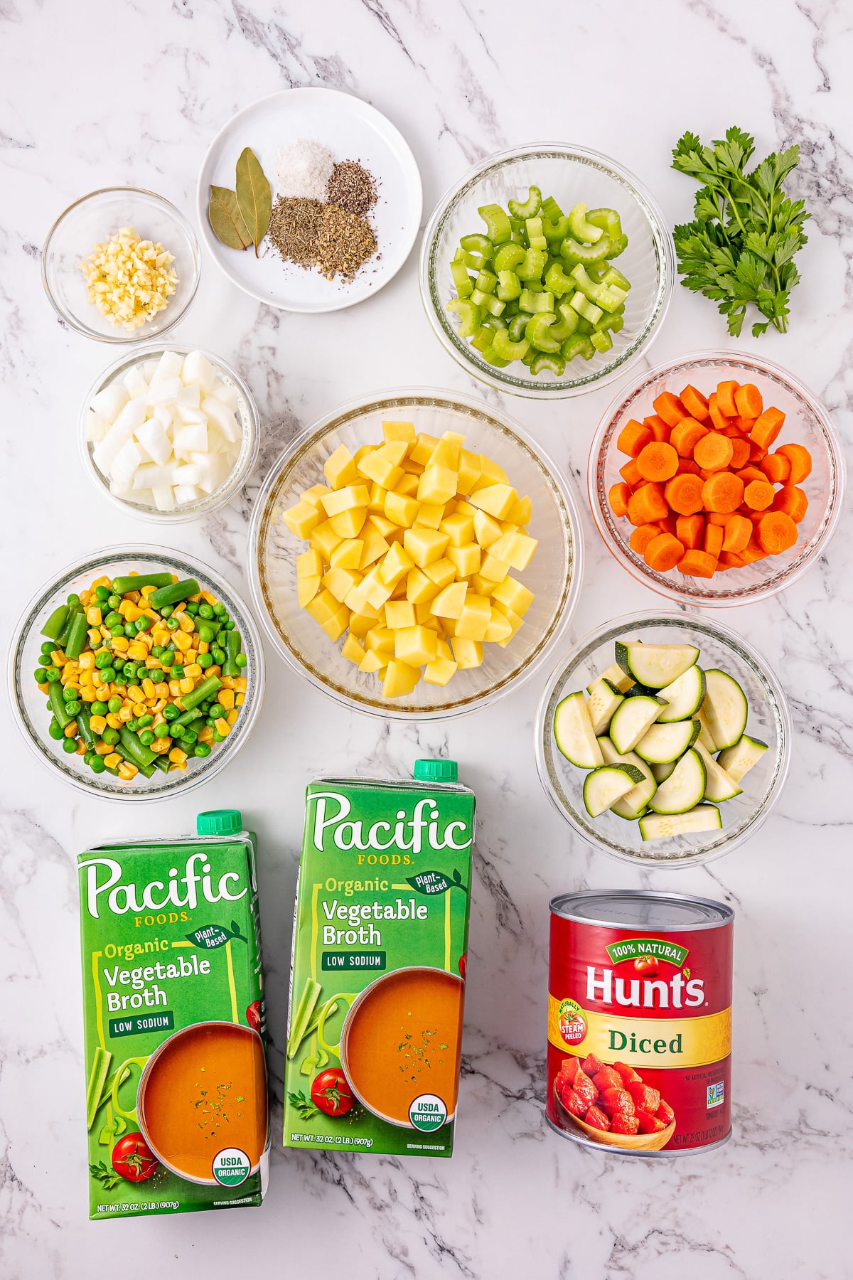 Crockpot vegetable soup ingredients laid out in bowls on kitchen counter.