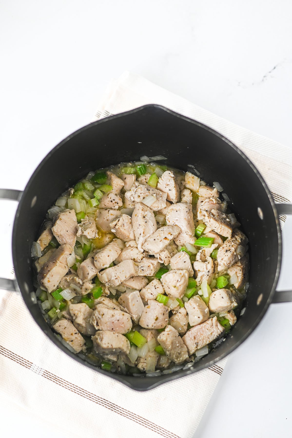 Onion and celery in bottom of pot with chicken.
