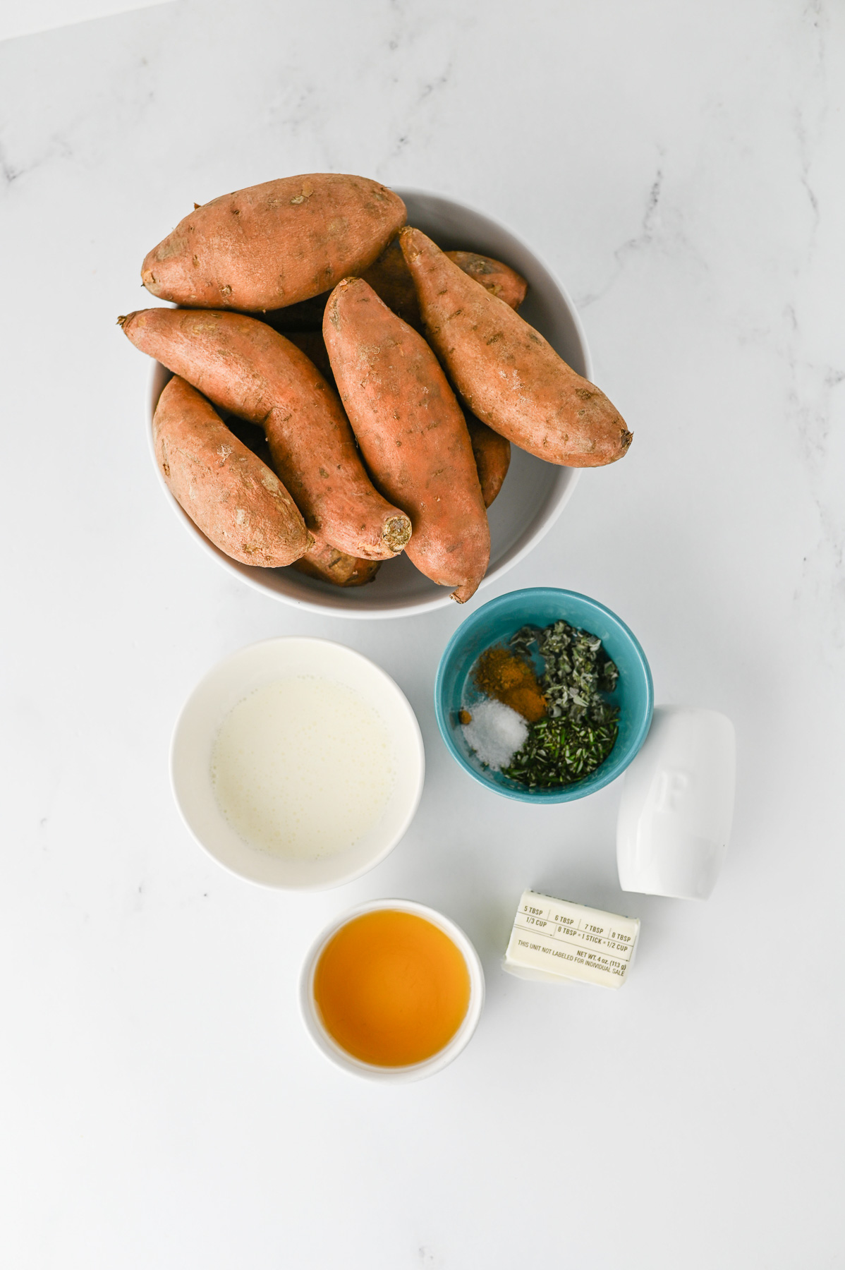 Ingredients for mashed sweet potatoes in small bowls on counter in prepration for the recipe.