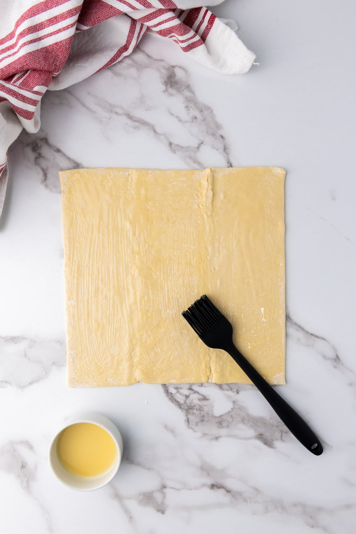 Puffed pastry is brushed with butter.