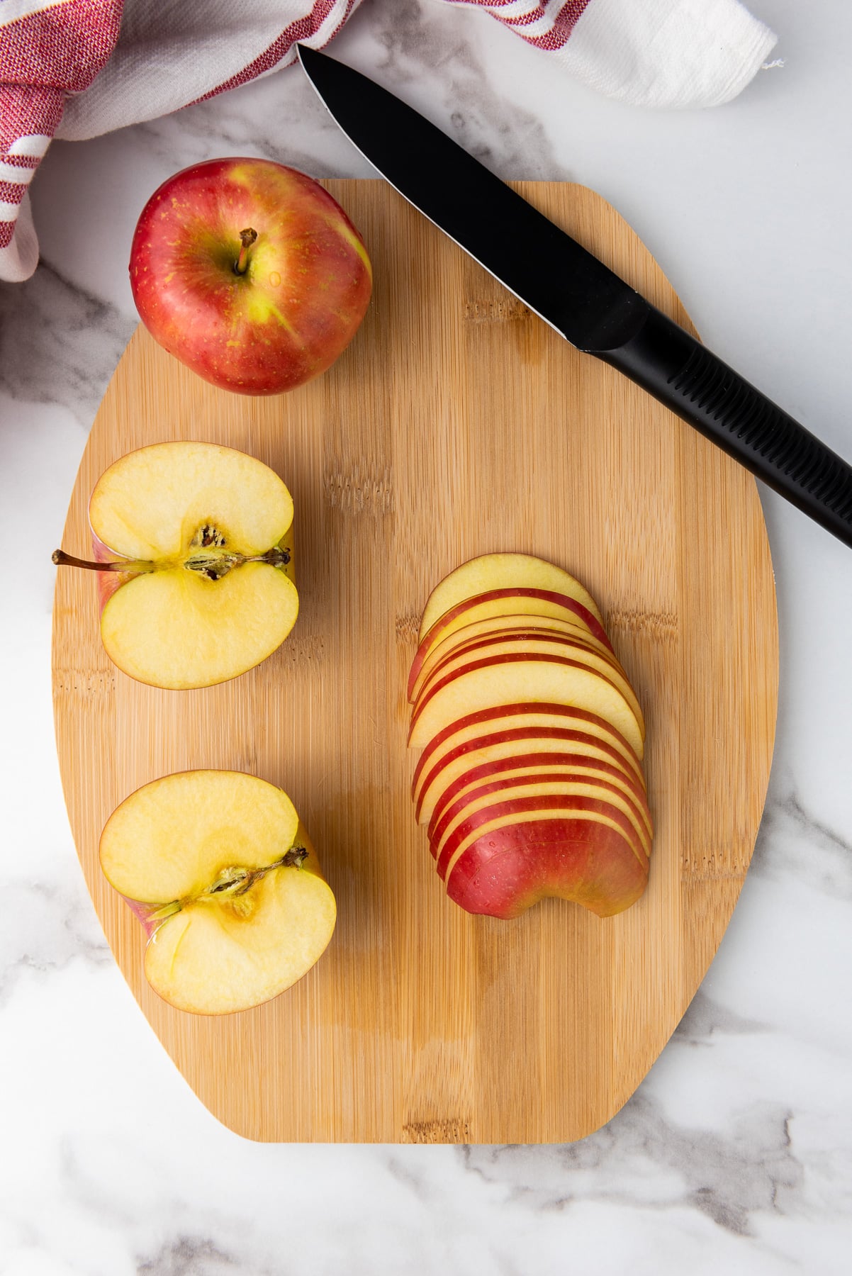 Sliced apples on wooden cutting board.