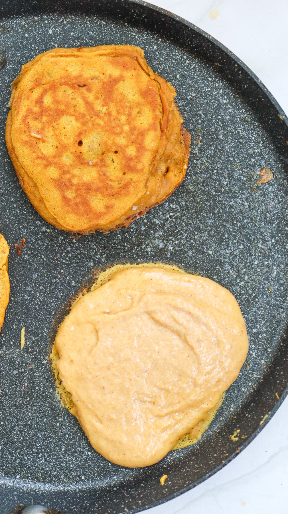 Pancakes cooking on griddle.